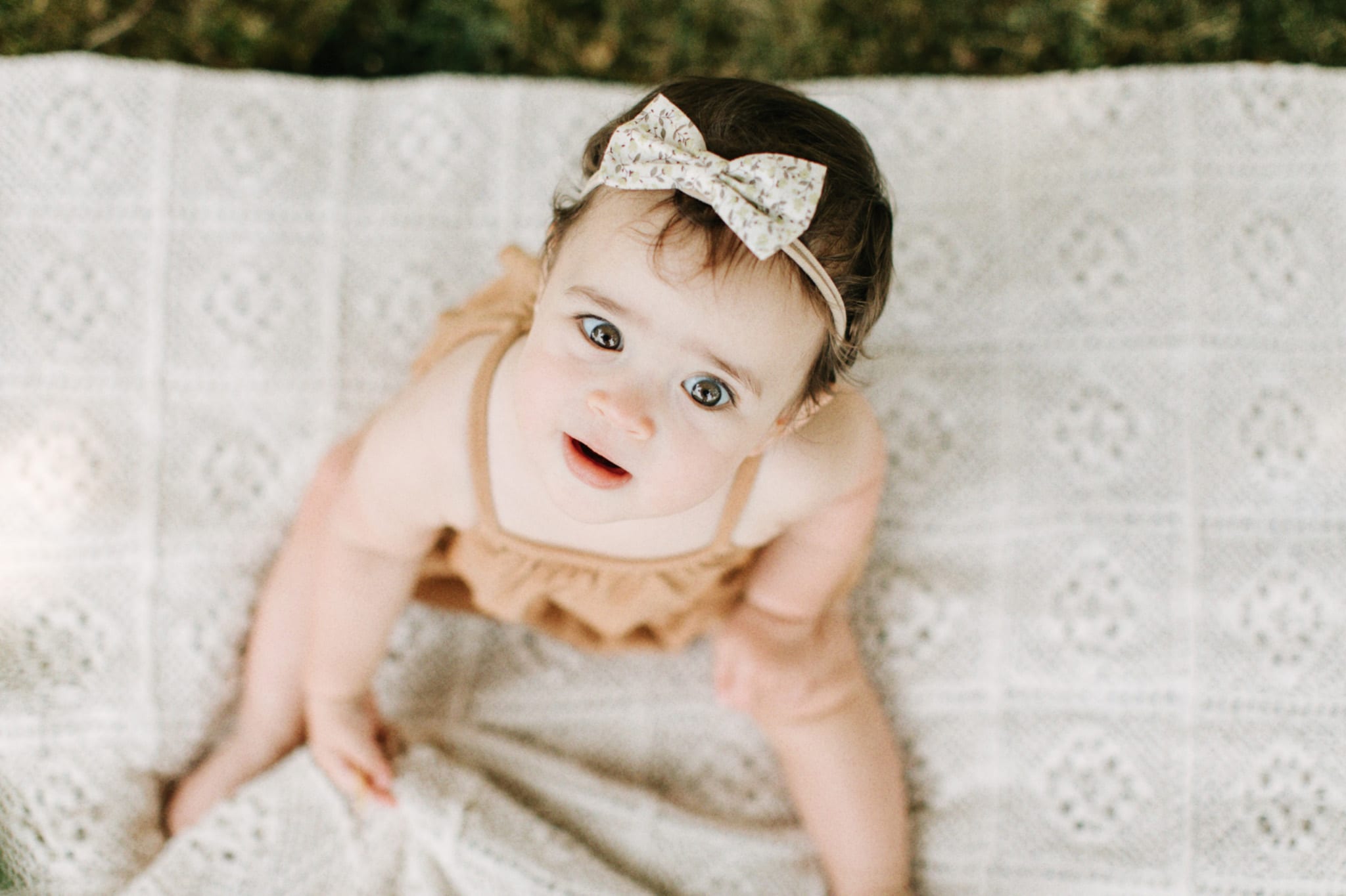 Baby girl looking up at camera during her baby photo session.