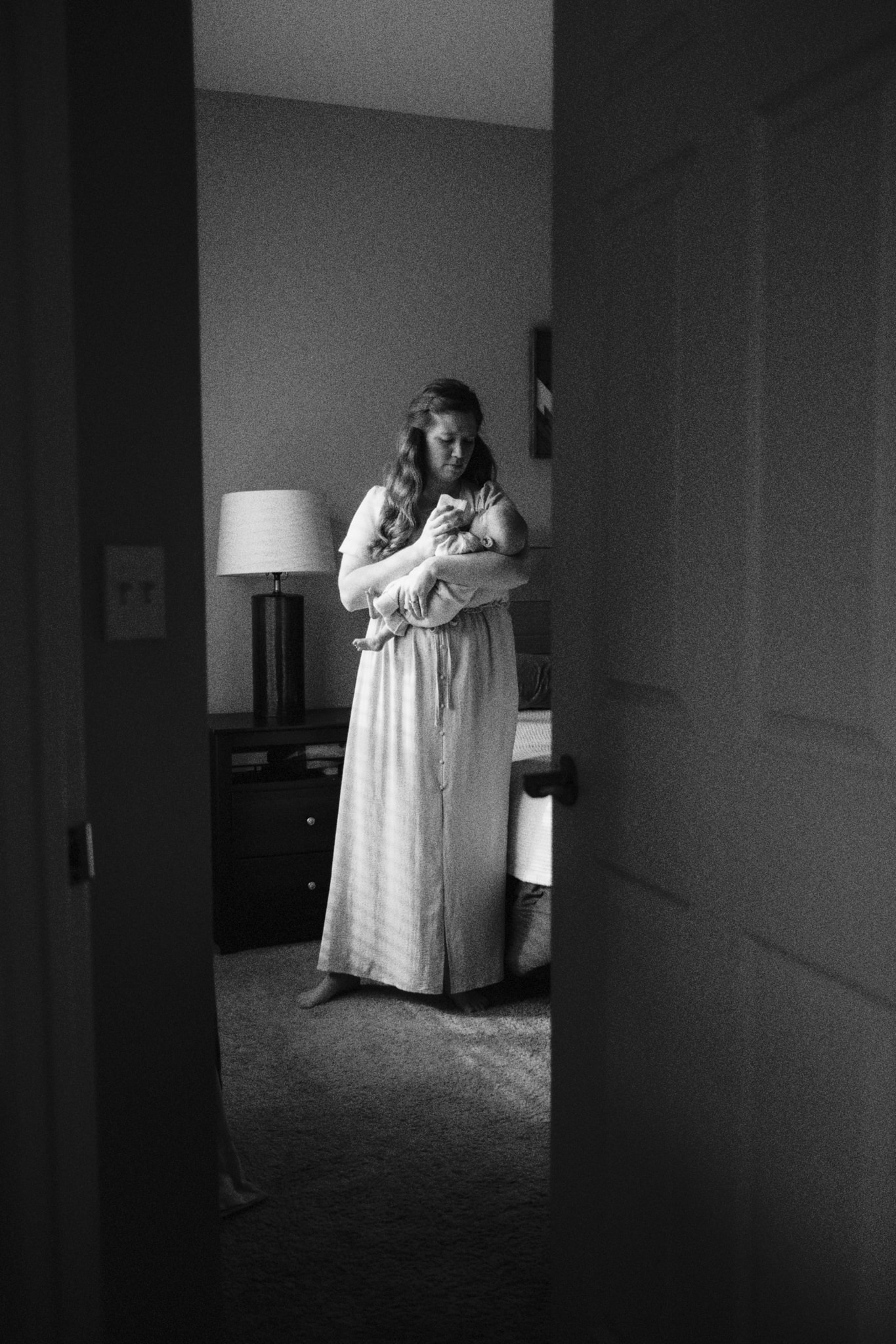 A black-and-white photo of mother holding baby during their baby newborn photography session.
