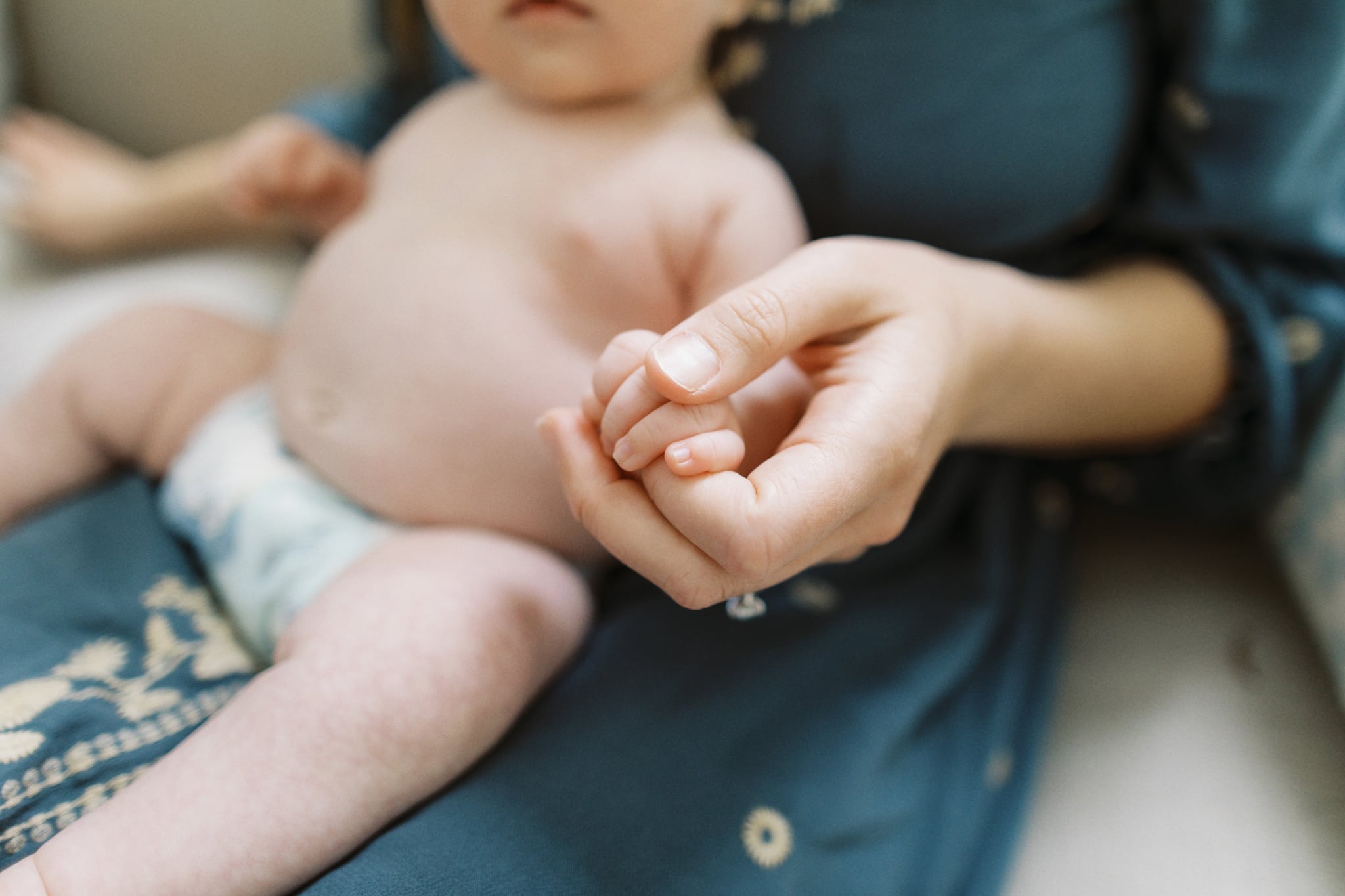 A close-up image of a baby while mother is holding her during their newborn photography session.